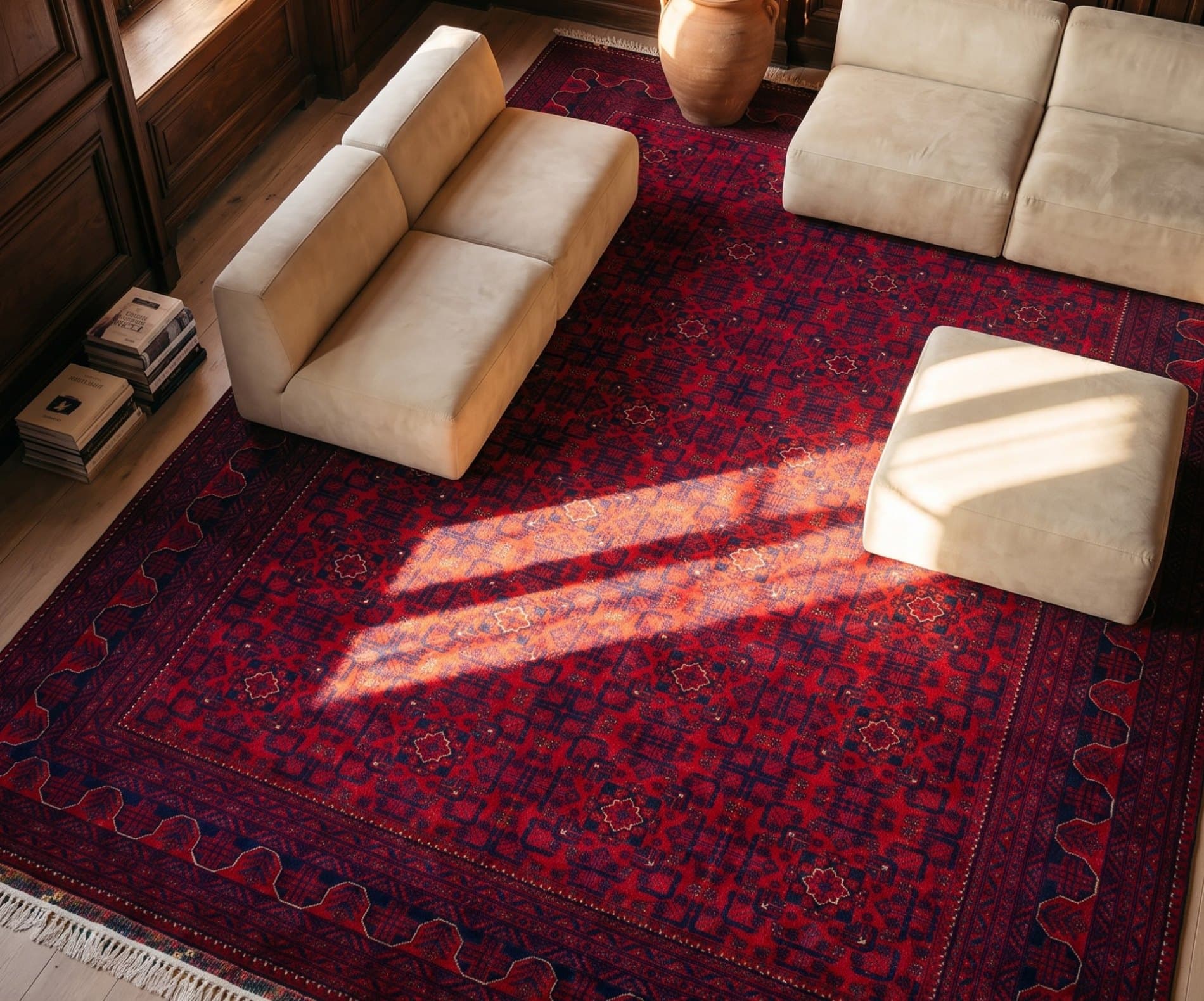 Cream sofas on a deep red rug in a sunlit room, seen from above